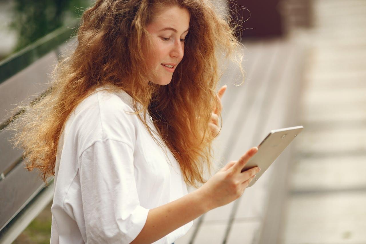 Девушка читает статью с планшета